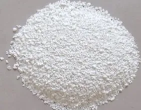 Heap of small white granules on a grey surface