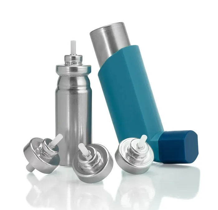 Metered-dose inhaler with a blue actuator beside an aluminium aerosol canister and three metering valves