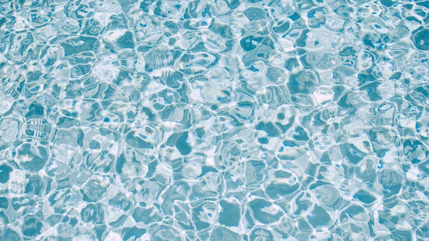 Rippling clear blue water with bright light reflections